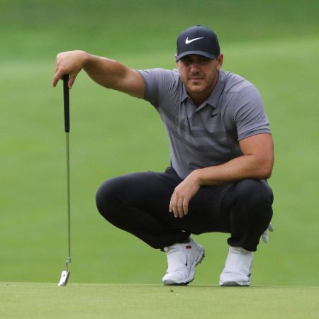 Brooks Koepka in a grey t-shirt poses at the golf  court.